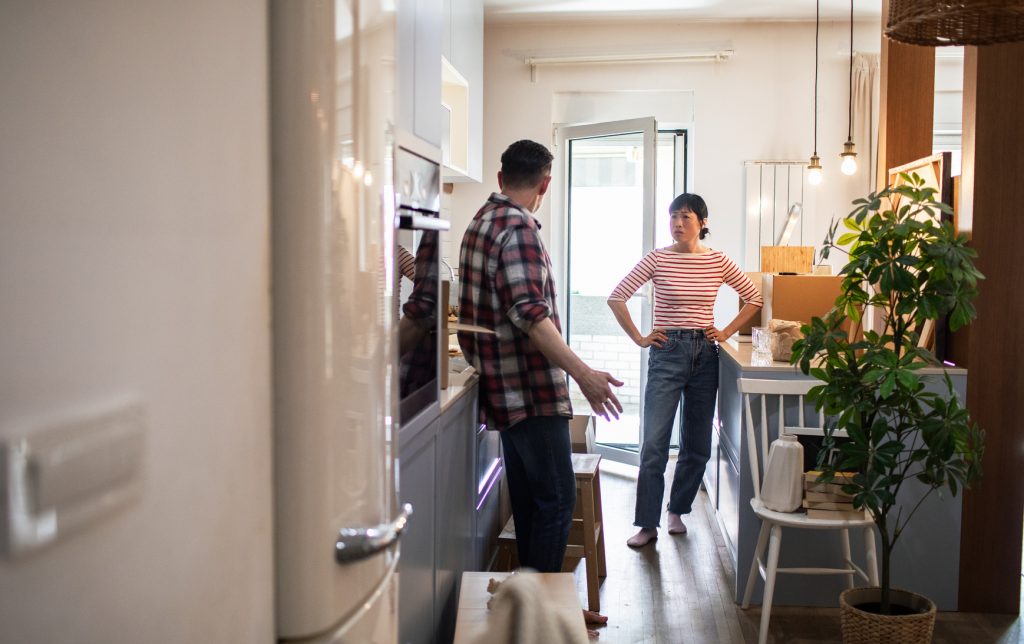 couple having a serious discussion while unpacking boxes at home