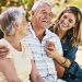 woman, grandparents and hug for family summer vacation, holiday or break together in the outdoors. happy grandma, grandpa and daughter with smile in joyful happiness, love or care for elderly parents