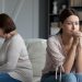 after quarrel silent daughter sitting aside of middle aged mother